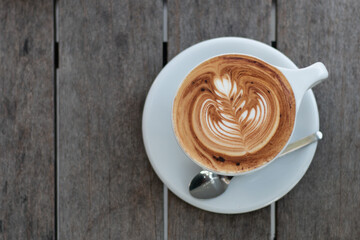 Close up Latte coffee with Latte Art serve on white cup and plate.