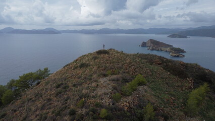 Fototapeta premium A man on top of an Kizil Ada island looks out into the Mediterranean sea from a drone.