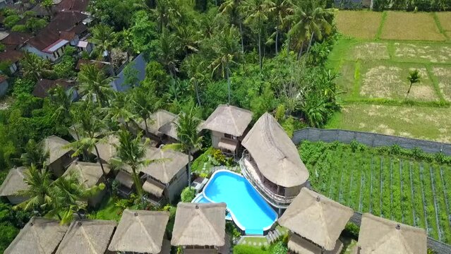Majestic aerial view flight drone top-down view of
Bamboo hut hotel resort blue Swimmingpool Bali, Ubud Spring 2017. High Quality 4k Cinematic footage