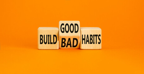 Build good or bad habits symbol. Concept word Build good or bad habits on wooden cubes. Beautiful orange table orange background. Business and build good or bad habits concept. Copy space.
