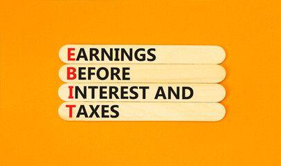 EBIT symbol. Concept words EBIT earnings before interest and taxes on wooden stick on beautiful orange background. Business EBIT earnings before interest and taxes concept. Copy space.