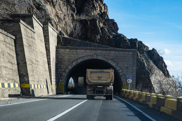 Industrial truck on the road, in motion. The truck enters the road tunnel.