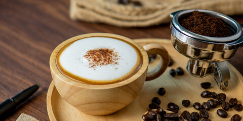 Hot coffee espresso latte with milk froth foam in wood cup. barista pouring milk liquid froth foam...