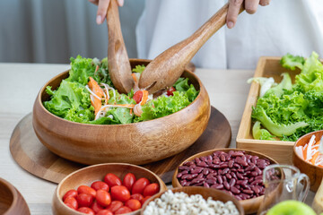 Hand chef mix fresh baby cos salad millet Crab Stick and pour salad dressing in wood blow. Organic Vegetables mix lunch with green salad In bowl. Breakfast fresh salad and clean vegetable