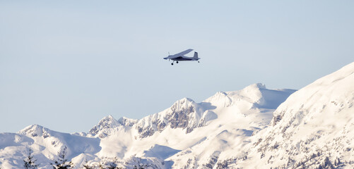 Fototapeta na wymiar Small Airplane flying around Canadian Mountain Landscape. Squamish, BC, Canada.