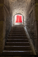 Old corridor with red curtain at the end. Concept for mystery, gothic, escape, hope.