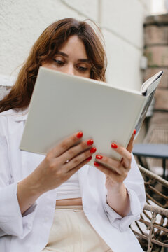Mockup image magazine book. The girl at the coffee shop table reading magazine.