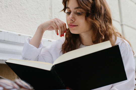 Mockup image magazine book. The girl at the coffee shop table reading book.