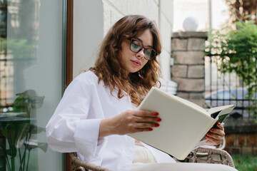 Mockup image magazine book. The girl at the coffee shop table reading magazine.