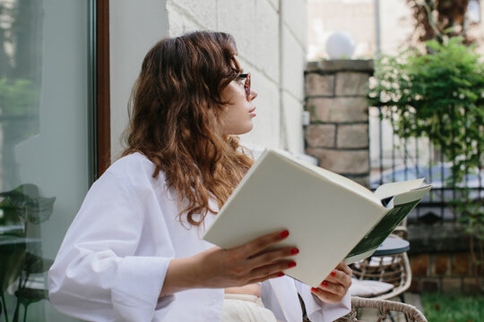 Mockup image magazine book. The girl at the coffee shop table reading magazine.