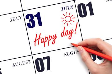 Hand writing the text HAPPY DAY and drawing the sun on the calendar date July 31