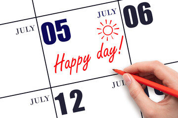Hand writing the text HAPPY DAY and drawing the sun on the calendar date July 5