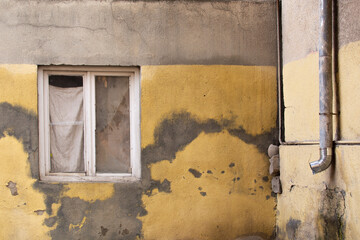 a window in an old yellow residential building in Tbilisi, Georgia
