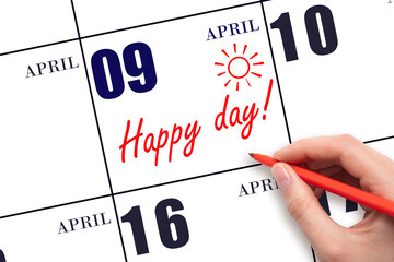 Hand writing the text HAPPY DAY and drawing the sun on the calendar date April 9
