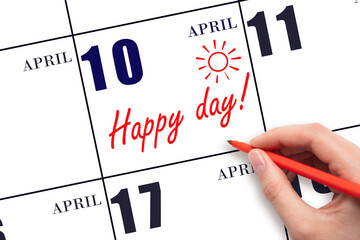 Hand writing the text HAPPY DAY and drawing the sun on the calendar date April 10