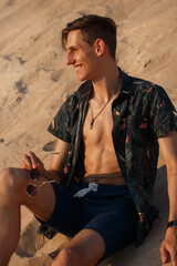 Cute happy hipster guy on the beach.