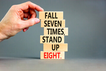 Stand up symbol. Concept words Fall seven times stand up eight on wooden blocks. Beautiful grey table grey background. Businessman hand. Business stand up concept. Copy space.