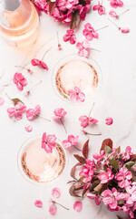 Obraz na płótnie Canvas Romantic spring evening with rose champagne and flowers, two vintage coupes champagne glasses with beautiful soft flowers, selective focus. Rose drink concept, pastel colors