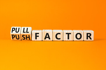 Pull or push factor symbol. Concept word Pull factor and Push factor on wooden cubes. Beautiful orange table orange background. Business pull or push factor concept. Copy space.