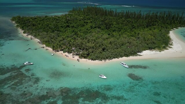 Motorboats bring tourists to ilot Moro to fish and grill their catch on the picturesque beach - descending aerial tilt up