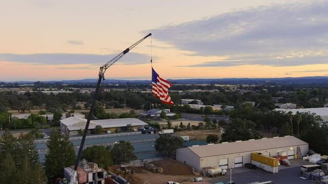American Flag Hanging On A Crane On The 4th Of July At Sunset In Windsor, California, USA. aerial orbit