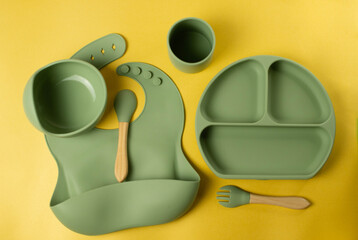 A set of children's silicone dishes. Baby feeding and nutrition concept. Top view, flat lay.