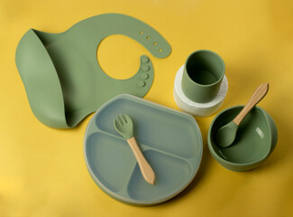 A set of children's silicone dishes. Baby feeding and nutrition concept. Top view, flat lay.
