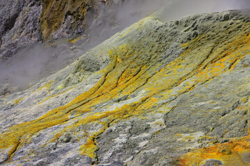 Closeup of a yellow sulphuric surface with crystels on the floor at a volcanic crater