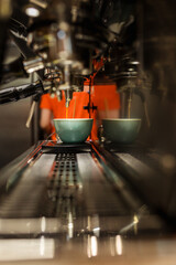Fototapeta na wymiar coffee machine prepares fresh coffee and pours into a cup in a restaurant, bar or pub..