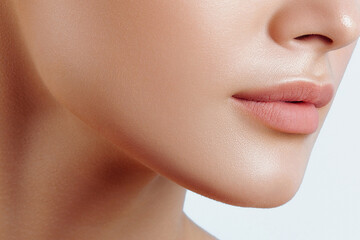 Lips of young beautiful woman closeup. Clean skin, nude makeup