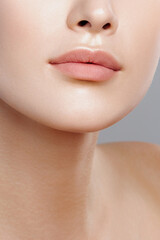 Obraz na płótnie Canvas Lips of young beautiful woman closeup. Clean skin, nude makeup