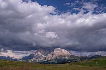Heavy cloud on top of Sassolungo and Sassopiatto mountains as seen from Alp di Siusi high mountain plateau , Seiser Alm, Dolomites, Trentino, Alto Adige, Italy