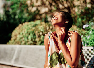 Woman smiling and enjoying the sun while relaxing outdoors at the park.