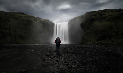 Waterfall in iceland with backpacker watching