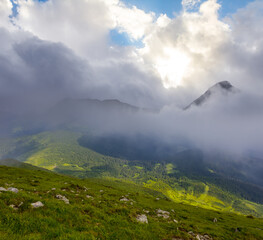 green mountain valley in dense mist and clouds