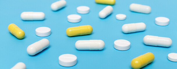 Pharmacy background. Pills and capsules on a blue background. Drugs are used to treat and treat a disease. Medicine, pharmacy and healthcare concept, medicine in medical clinic. Banner.
