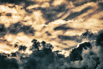 close up of fluffy light and dark cumulus clouds at sunset