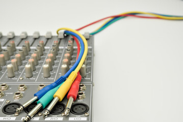 Multicolor audio jacks on music mixing console for connecting music devices. Different colors audio cables for connecting and recording music instrument.