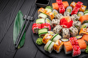 Big set of Asian food. Sushi and rolls on a dark background.