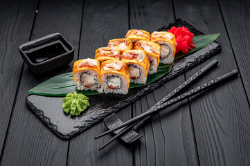 Traditional delicious fresh sushi roll set on a black background . Sushi roll with rice, cream cheese, salmon.