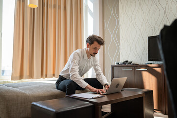 One man adult Caucasian male work on laptop computer from hotel room