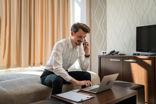 One man adult Caucasian male work from hotel room make a call on phone