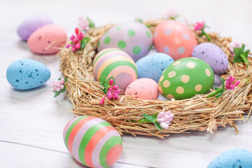 Fototapeta na wymiar Easter eggs in the nest on a light wooden background. High quality photo