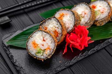 Hot tempura roll with salmon and cheese, Traditional delicious fresh sushi roll set on a black background.