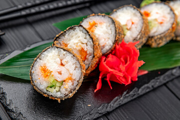 Hot tempura roll with salmon and cheese, Traditional delicious fresh sushi roll set on a black background.