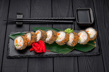 Hot tempura roll with salmon and cheese, Traditional delicious fresh sushi roll set on a black background.