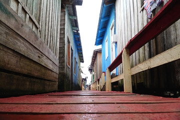 View over the wooden walkways next to facades of simple pile dwellings built on high stilts near...