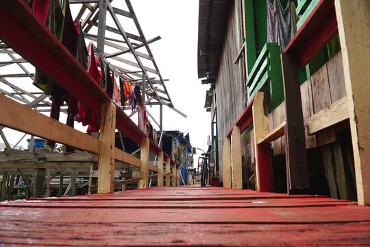 View over the wooden walkways next to facades of simple pile dwellings built on high stilts near the Amazon riverbank. Castanho Careiro village, Amazonas, Brazil.