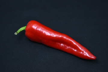 Large red capsicum on a black background. Hot red pepper. Capsicum.
