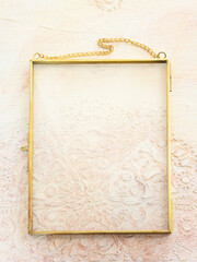 Image of gold tone metal vintage empty photo frame over textured white wooden background. For mockup, can be used for photography montage